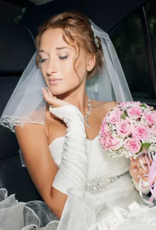 bride in limo holding flowers